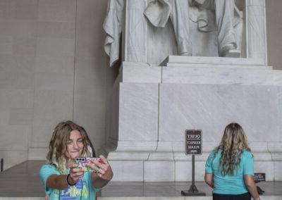 2 students standing in front of the statue of Abraham Lincoln at the Lincoln Memorial in Washington D.C.